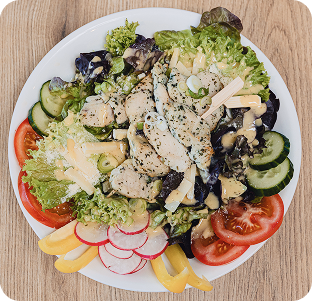 Hähnchensalat mit frischem Gemüse, darunter Gurken, Tomaten, Radieschen und Paprika.