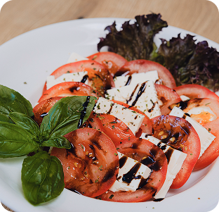 Tomate-Mozzarella-Salat mit Basilikum und Balsamico-Dressing.
